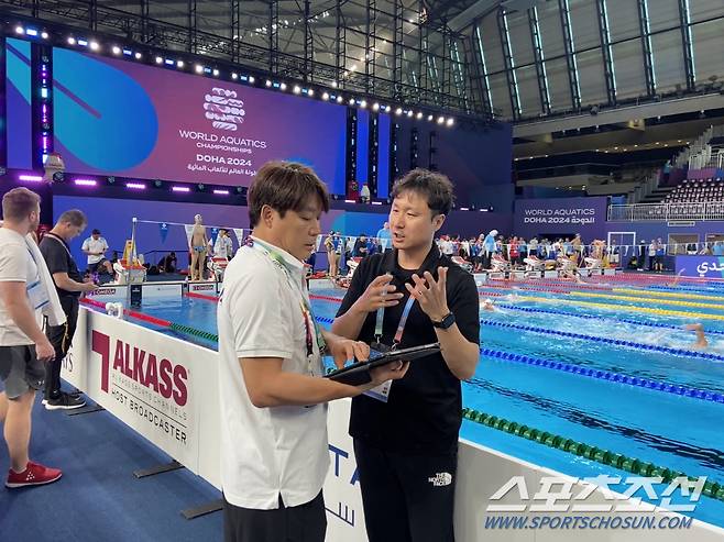 전동현 수영대표팀 코치와 김형석 진천선수촌 영상분석관(과장)이 예선 영상 분석 데이터를 보며 의견을 나누고 있다.