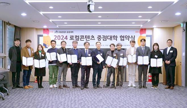 지난 19일 서울 마포구 소진공 드림스퀘어에서 소진공 관계자들이 12개 지역 대학과 2024년 로컬콘텐츠 중점대학 업무협약을 체결한 후 기념촬영을 하고 있다. 소상공인시장진흥공단 제공