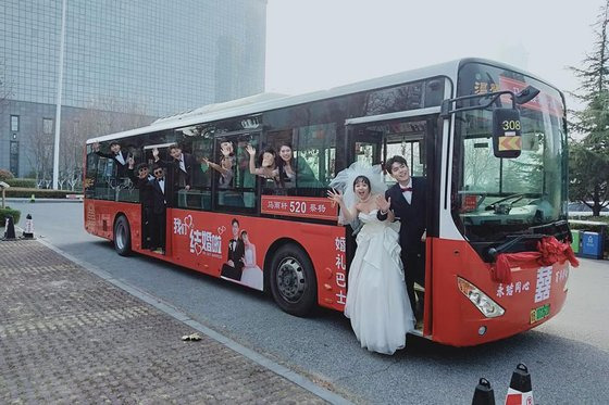 산둥(山東)성 칭다오(?島)시에서 온 마위쉬안(馬雨軒)·차이양(蔡楊) 부부가 하객들과 웨딩 버스에 올라 사진을 찍고 있다. 신화통신