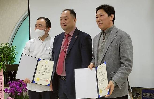  김정학 한국조리사협회중앙회장이 대전시장을 대신해 시상을 하고 기념촬영을 하고 있다.