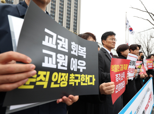 한국교원단체총연합회와 교사노동조합연맹·전국교직원노동조합 등 단체 회원들이 20일 오전 정부서울청사 앞에서 기자회견을 열고 지난해 숨진 서울 서이초 교사의 순직을 인정하고 관련 제도 개선을 촉구하는 손팻말을 들고 있다. 연합뉴스