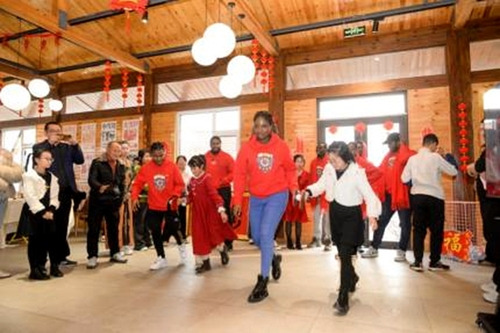 Overseas students and villagers play games together.