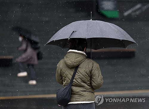 21일 오후 눈이 내리는 서울 용산역 앞에서 시민들이 우산을 쓴 채 걸어가고 있다. [연합뉴스]