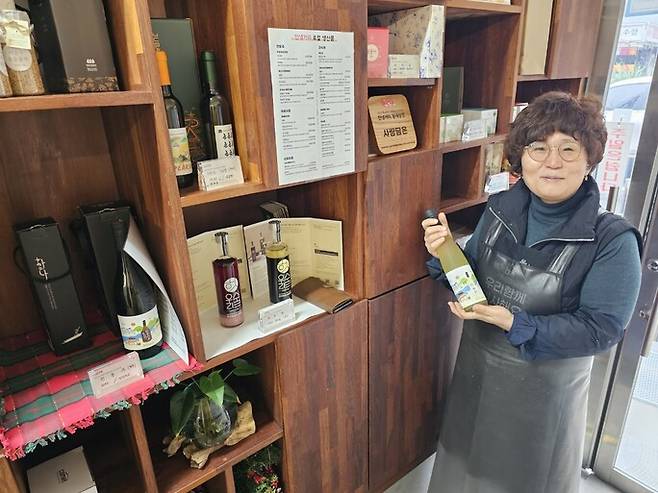 자칭 ‘어궁동 엄마’인 한정식집 ‘사랑담은’의 김효임 사장이 지역 제품을 홍보하는 진열장 앞에 서 있다. 최예린 기자
