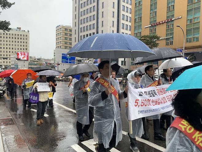 ▲비바람이 거셌던 21일 오후 2시 서울 중구 을지로 인쇄인 100여 명이 우비를 입고 중구청 앞에 모였다. '인쇄인 생존권 수호를 위한 총궐기대회'를 위해 중구청 앞에 모인 이들은 충무로를 거쳐 서울시청 앞으로 1시간 가량 행진했다. 사진=윤유경 기자.