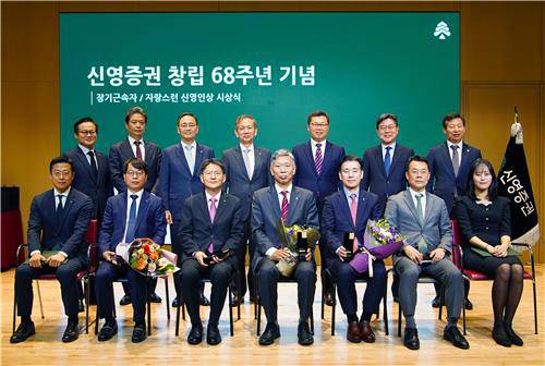 원종석 대표이사(뒷줄 오른쪽에서 세 번째)와 황성엽 대표이사(뒷줄 오른쪽에서 네 번째)가 장기근속 수상자들과 기념촬영을 하고 있다. <신영증권 제공>