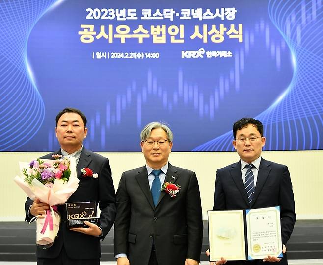 박성진 제이브이엠 경영관리본부 이사(왼쪽)와 박진홍 프로(왼쪽 세번째)가 홍순욱 한국거래소 코스닥시장본부장(가운데)으로부터 '종합평가 우수법인' 수상을 했다.