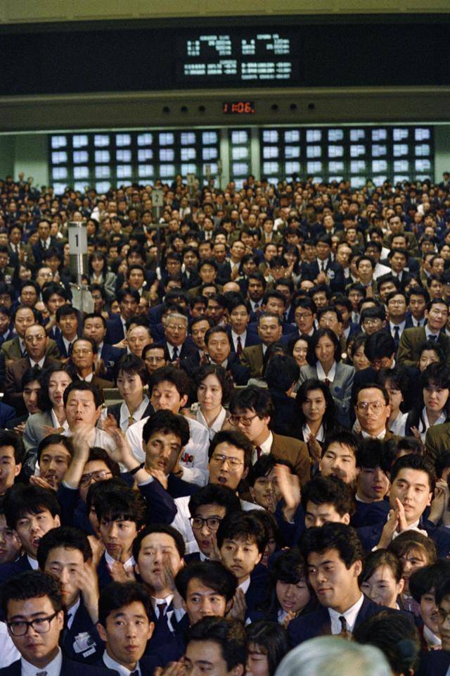 1987년 12월 28일 도쿄 증권거래소의 연말 폐장식에서 주식 딜러와 거래자들이 미국 달러가 전후 최저 수준으로 떨어지자 박수를 치고 있다. 1990년대 들어 일본 경제의 거품이 붕괴되기 전까지 주식을 비롯한 모든 자산이 오르고 유흥가가 불야성을 이루는 등 일본 전체가 버블에 취해 흥청거렸다. AFP 연합뉴스 자료사진