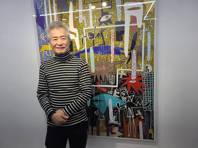 최울가(WoolGa Choi) 작가가 ‘최울가 전용 갤러리’에서 작품을 배경으로 인터뷰를 하면서 포즈를 취하고 있다. 그는 울산과 집(家)을 합친 말이 자신의 이름이라며 작품 뿌리엔 늘 한국적 정서가 자리하고 있음을 은근히 강조했다.