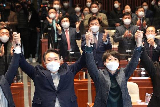 2022년 1월 6일 당시 국민의힘 윤석열 대선 후보와 이준석 대표가 서울 여의도 국회에서 열린 의원총회에서 화해하며 잡은 손을 들어올리고 있다. 다음날 윤 후보는 페이스북을 통해 여성가족부 폐지 공약을 밝혔다. 뉴스1