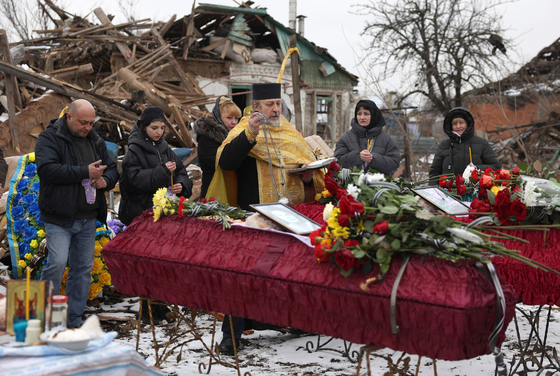 23일 우크라이나 도네츠크주 크라마토르스크에서 한 성직자가 러시아의 미사일 공격으로 숨진 주민들의 장례식을 주도하고 있다. [AFP=연합뉴스]