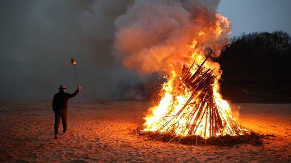 임기주 회장이 달집 옆에서 불을 담은 깡통을 돌리며 쥐불놀이를 하고 있다.&nbsp;