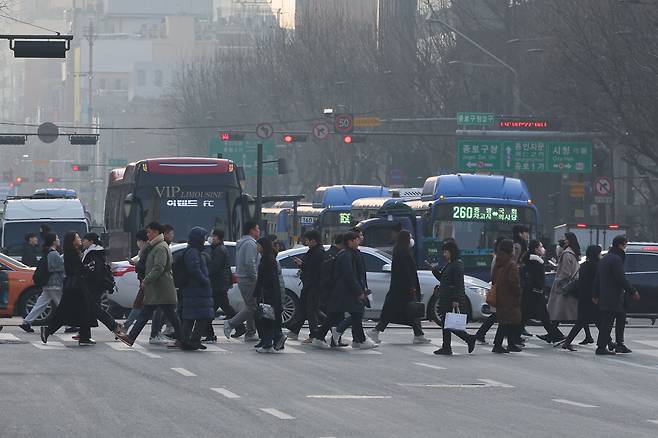 설 연휴 다음날인 지난 13일 오전 출근길에 오른 시민들이 서울 광화문 네거리 횡단보도를 건너고 있다. /연합뉴스