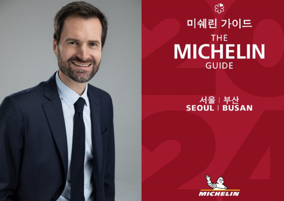 Michelin Guide's international director Gwendal Poullennec, left, and the cover of The Michelin Guide Seoul and Busan 2024, which was released Thursday [MICHELIN GUIDE KOREA]