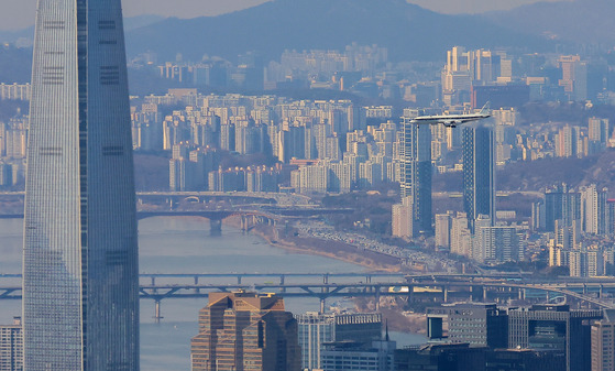 NASA's research DC-8 aircraft fitted with air quality measurement equipment passes near Lotte Tower in southern Seoul on Monday morning. Korea and the United States kicked off ASIA-AQ, a research campaign to uncover the cause of air pollution in Asia, deploying cutting-edge equipment, including the GEMS satellite and Gulfstream and DC-8 aircraft from February to March, when air pollution is most severe. [YONHAP]