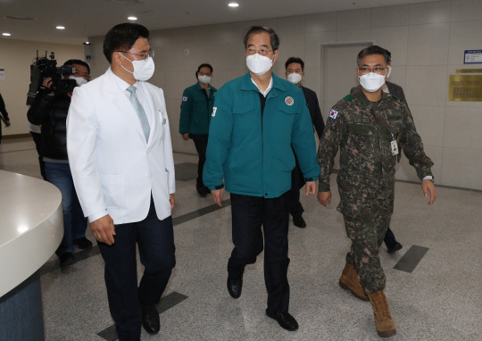 전공의 파업이 이어지는 가운데 25일 오후 한덕수(가운데) 국무총리가 경기 성남시 분당구 국군수도병원을 방문, 민간인 중환자 가족들을 격려 한 후  석웅(왼쪽) 국군수도병원장의 안내를 받고 있다. 뉴시스