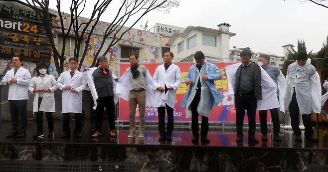 전라북도의사회가 15일 전북 전주시 완산구 전동 풍남문광장에서 열린 의대 정원 증원 반대 집회에서 의사 가운을 벗는 퍼포먼스를 하고 있다.[연합]