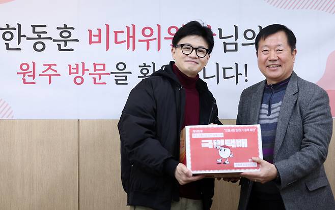 국민의힘 한동훈 비상대책위원장이 26일 강원 원주시 자유시장에서 열린 전통시장 상인회 간담회에서 백귀현 원주중앙시장 상인회장으로부터 전통시장 살리기 정책 제안이 담긴 국민택배 상자를 받은 뒤 기념 촬영하고 있다. [사진 = 연합뉴스]