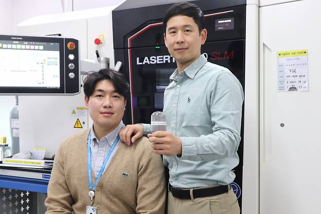 박형기(오른쪽) 한국생산기술연구원 박사가 차세대 금속 3D 분말소재를 들어보이고 있다.[한국생산기술연구원 제공]