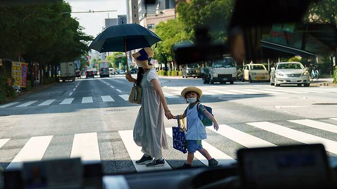 아이를 데리고 횡단보도를 건너는 일본 여성