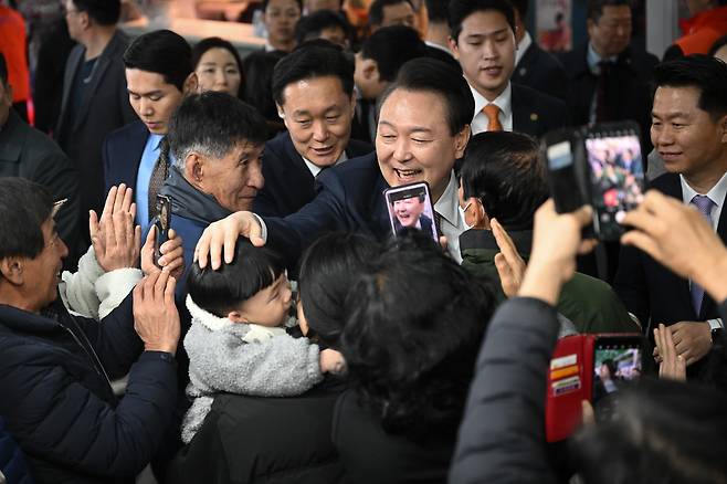 윤석열 대통령이 2월26일 충남 서산 동부 전통시장을 방문해 시민, 상인들과 인사하고 있다. ⓒ대통령실 제공