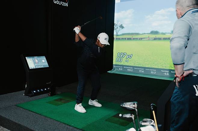 골프존·골프존데카 '2023 PGA 머천다이즈 쇼'에 참가한 관람객이 골프존 시뮬레이터 제품을 체험하고 있다. /골프존 제공