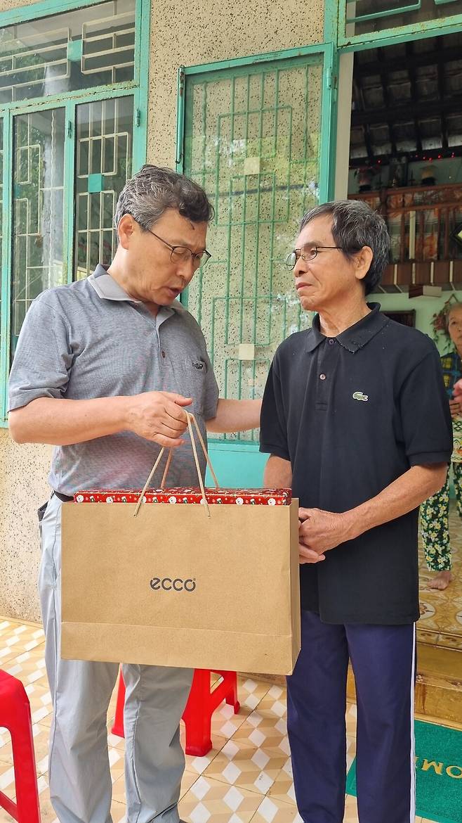 2기 진실화해위 위원장을 지낸 정근식 서울대 명예교수가 1월10일 하미 마을을 방문해 하미 학살 사건 생존자인 응우옌럽씨에게 선물을 전달하고 있다. 정근식 제공