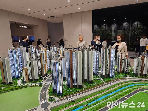 '트리우스 광명' 견본주택에서 방문객들이 단지 모형도를 보고 있다. [사진=안다솜 기자]