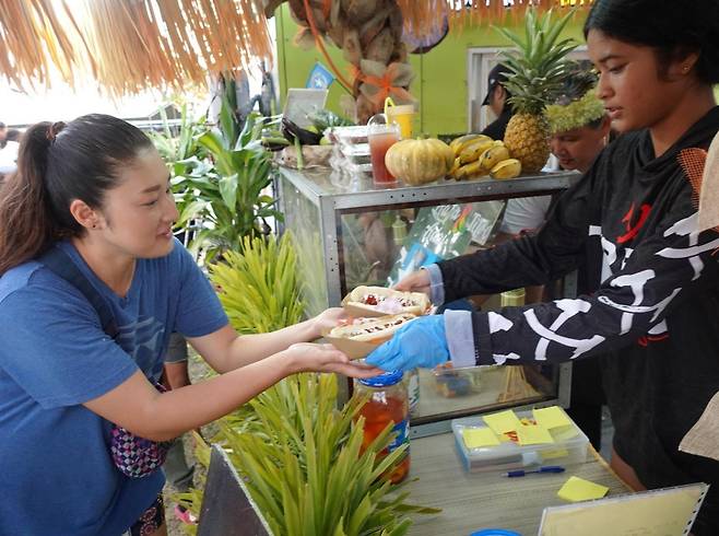 축제장에서 합리적 가격으로 음식을 구입하는 여행객