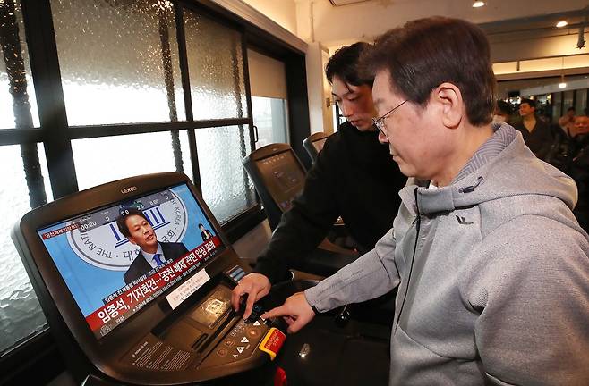 이재명 더불어민주당 대표가 2월28일 오전 서울 서대문구 매직짐 휘트니스에서 러닝머신을 이용하는 중, 화면에 임종석 전 대통령비서실장의 공천 관련 기자회견 모습이 보이고 있다. ⓒ국회사진취재단