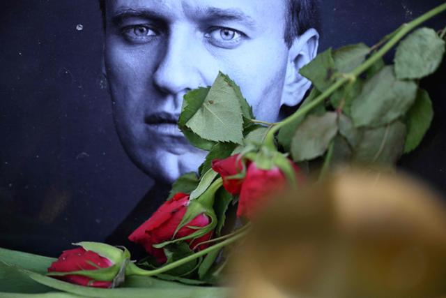 지난달 29일 독일 서부 프랑크푸르트암마인에 마련된 러시아 야당 지도자 알렉세이 나발니 임시추모비 앞에 나발니 사진과 장미가 놓여 있다. 프랑크푸르트암마인=AFP 연합뉴스