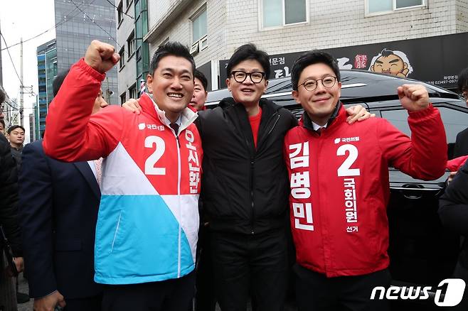 한동훈 국민의힘 비상대책위원장이 20일 오후 서울 광진구 화양동에서 '시민이 안전한 대한민국' 현장 공약 발표를 하기 위해 이동하기 전 단수공천을 받은 오신환(왼쪽) 광진을 후보, 김병민 광진 갑 후보와 함께 손을 들고 있다. (공동취재) 2024.2.20/뉴스1 ⓒ News1 임세영 기자