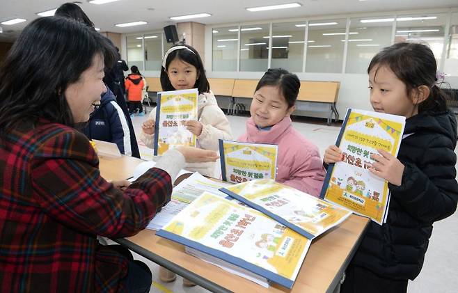 울산지역 초등학교 신입생 예비소집일인 지난 1월 3일 오전 울산 중구 울산초등학교 가입학식에서 예비 초등학생들이 교사로부터 교재를 전달받고 있다. 뉴시스