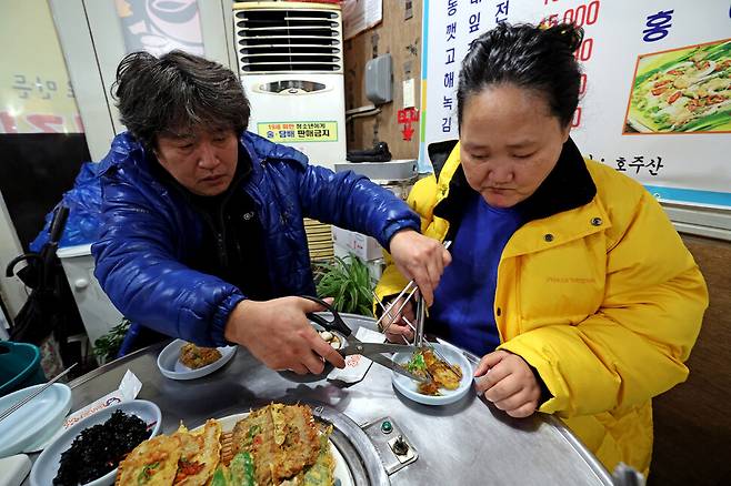 한 대표가 2월13일 저녁 한 식당에서 누나 한신예씨가 먹기 좋은 크기로 음식을 잘라주고 있다. 이정용 선임기자