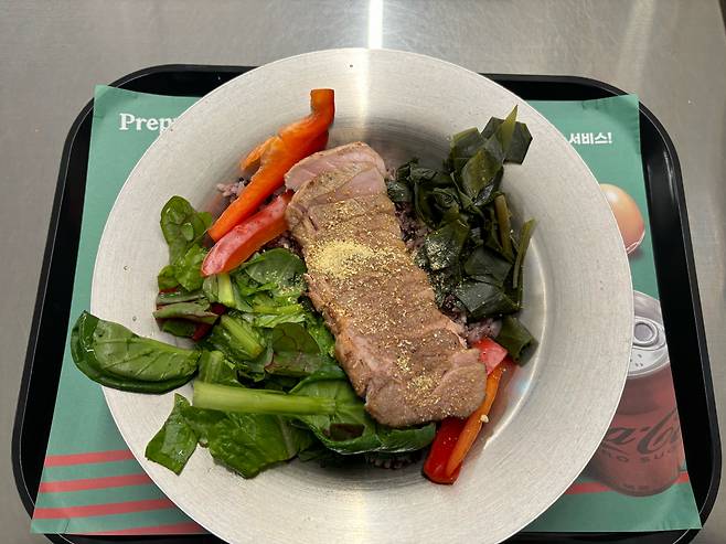 Prepper's Pork and garlic leaf salad bowl (Kim Da-sol/The Korea Herald)