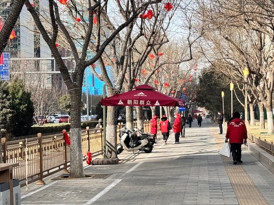 2일 베이징 도심 창안대가에 설치된 기층 조직 차오양군중 초소에 붉은 유니폼을 입은 인원이 행인들을 감시하고 있다. 신경진 기자