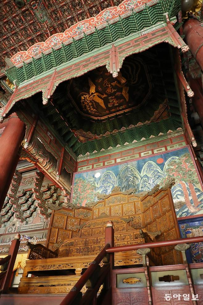 어좌(御座) 뒤로는 임금이 다스리는 삼라만상을 상징하는 해와 달 그리고 다섯 개의 봉우리가 그려진 일월오봉도가 있습니다. 또 천장에는 봉황 나무 조각이 새겨져 있습니다.