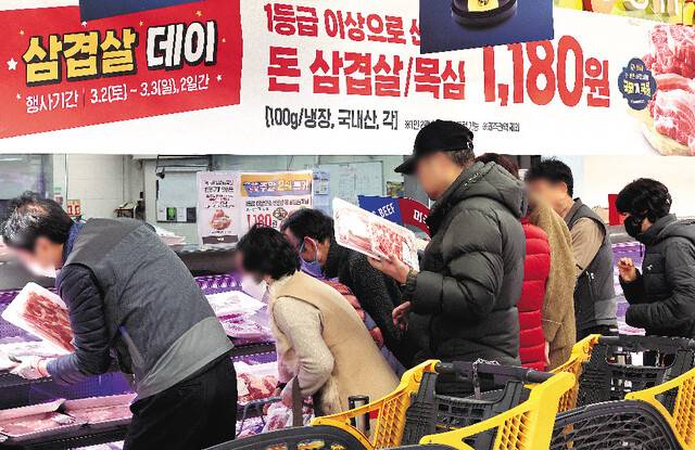 시민들이 3일 '삼겹살데이' 할인행사가 열린 서울 한 대형마트 정육 코너에서 다양한 돼지고기 제품을 고르고 있다. 연합뉴스