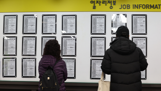 Job seekers look over job information at the Seoul Western Employment Welfare Plus Center in western Seoul on Feb. 16. [YONHAP]