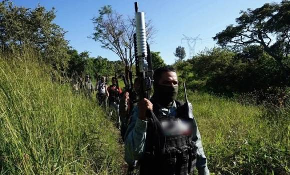 사진=무장한 에콰도르 갱단이 줄지어 길을 걷고 있다