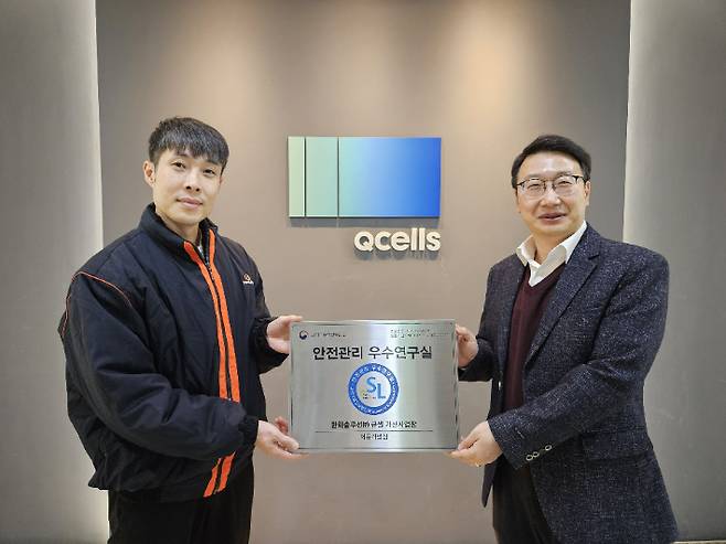 한화큐셀 박정필 시스템개발센터장(오른쪽)과 정상민 제품개발팀장이 서울 금천구 시스템개발센터에서 '안전관리 우수연구실' 인증패를 들고 기념 촬영을 하고 있다. 한화큐셀 제공
