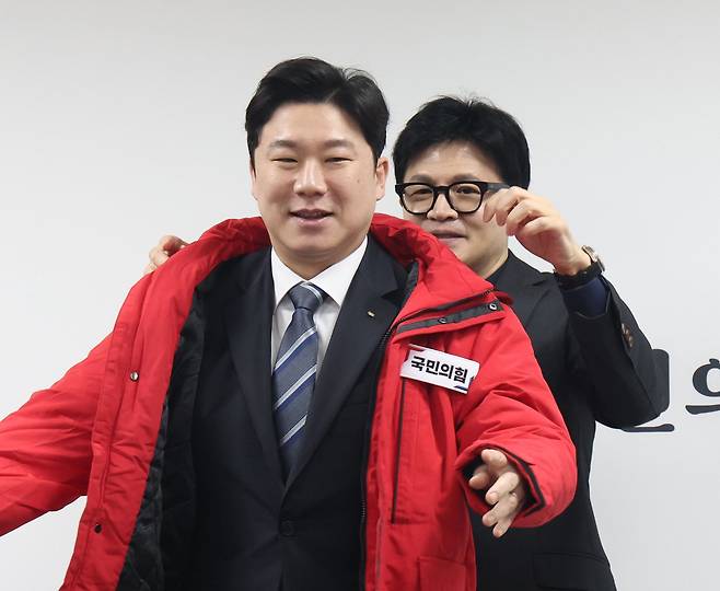 한동훈 국민의힘 비상대책위원장이 지난달 5일 서울 여의도 국회 국민의힘 당사에서 열린 인재 영입 환영식에서 진종오 전 국가대표 사격선수에게 국민의힘 옷을 선물하고 있다. /뉴스1