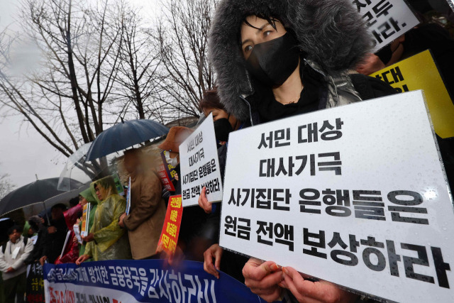 금융정의연대 등 단체 회원들이 지난달 15일 서울 종로구 감사원 앞에서 열린 홍콩 ELS 대규모 손실 사태와 관련해 금융 당국에 대한 감사원 공익 감사 청구 기자회견에서 팻말을 들고 있다. 연합뉴스