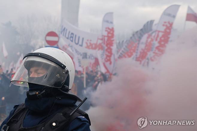 (바르샤바 AFP=연합뉴스) 6일(현지시간) 폭죽 터트리며 시위하는 농민들과 경찰. 2024. 3. 6