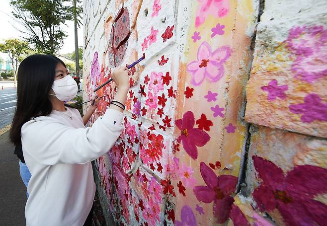 12월 24일 경기도 수원시 장안구 주안말 사거리에서 조원고 학생들이 오래된 벽화를 수정ㆍ보완하는 작업을 하고 있다.   조원고 학생들은 코로나 블루 극복 등을 위해 학교 앞 주안말 사거리 벽화를 수정ㆍ보완해 그리는 프로젝트를 진행하고 있다. /연합뉴스