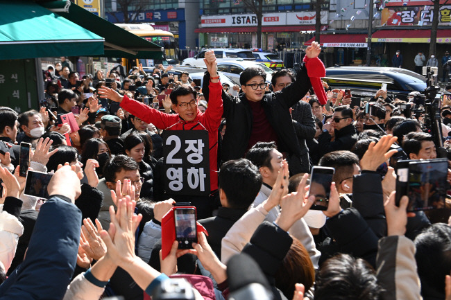 한동훈(단상 가운데) 국민의힘 비상대책위원장이 8일 오전 경기 성남 수정구 중앙시장 사거리에서 ‘이재명 저격수’로 불리며 성남 수정구에 출마한 장영하(왼쪽) 변호사의 손을 번쩍 들고 시민들의 환호에 답하고 있다. 윤성호 기자