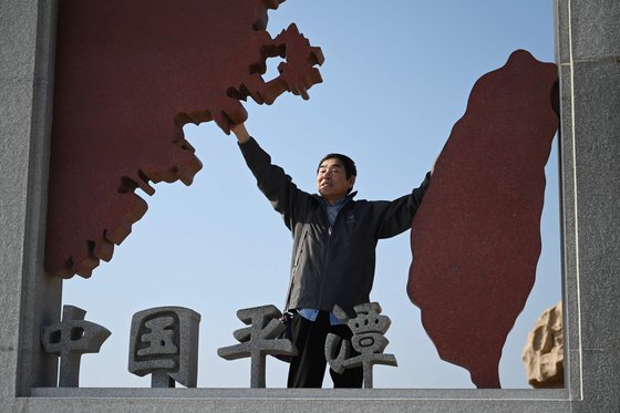 지난 1월 대만과 인접한 중국 푸젠성 핑탄섬에서 한 관광객이 중국 본토와 대만을 형상화한 조형물과 함께 기념 사진을 찍고 있다. AFP=연합뉴스