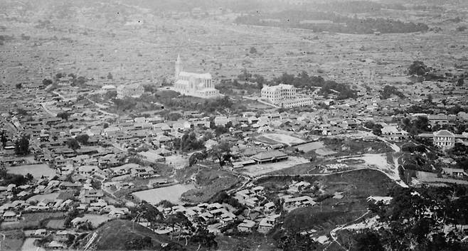 남산에서 바라본 명동 일원. 뽀족한 첨탑의 명동성당 우측으로 샬트르 성 바오로 수녀회 건물이, 좌측으로 사제관이 보인다. [서울역사박물관(성 베네딕도 상트 오틸리엔 수도원 소장 서울사진)]