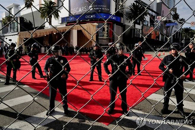 Members of security stand guard as pro-Palestinian demonstrators take part in a protest near the perimeter of the 96th Academy Awards, amid the ongoing conflict between Israel and the Palestinian Islamist group Hamas, in Los Angeles, California, U.S., March 10, 2024. REUTERS/Carlin Stiehl TPX IMAGES OF THE DAY