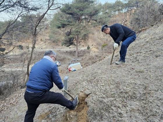 지난 9일 경북 봉화에서 장례지도사 박인식 두손장례개발 대표가 인력사무소 인부 A씨와 함께 삽으로 고(故) 오장섭씨 묘를 파는 모습. 이찬규 기자